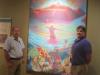 Earl Barbry Jr. (right) and Brent Barbry Sr. stand in front of a painting depicting the “creation story” of the Tunica people, which is displayed in the Tunica-Biloxi Museum in Marksville. {Photo by Raymond L. Daye}